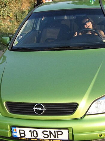 "This bitch is driving her green cuntbox while rocking some shades."