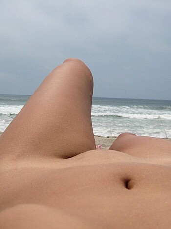 Brunette with pierced nipples on nudist beach - Photo 12