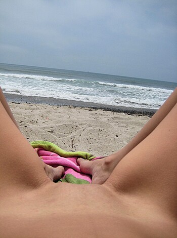 Brunette with pierced nipples on nudist beach - Photo 15