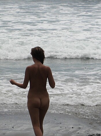 Brunette with pierced nipples on nudist beach - Photo 20