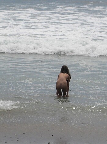 Brunette with pierced nipples on nudist beach - Photo 22