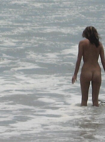 Brunette with pierced nipples on nudist beach - Photo 24