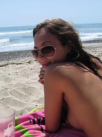 Brunette with pierced nipples on nudist beach - Photo 35