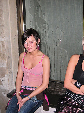 The f**kin' blonde bitch in her black bra, sittin next to the cunt with the pink tits.