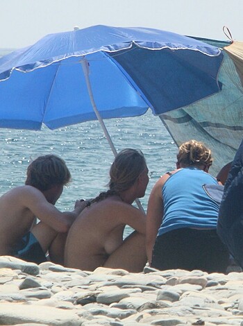 A bunch of naked fuckers lounging around on the sandy shore while getting roasted by the hot sun.