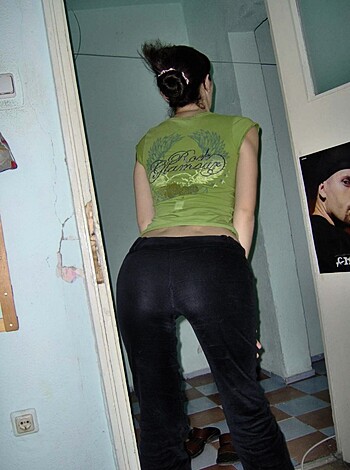 A close-up shot of a hot chick's butt and thighs, showing off her skin-tight black pants and green tank top.