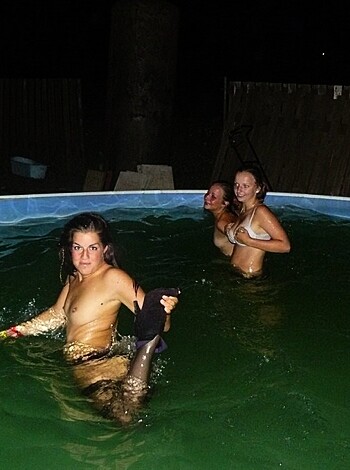 A group of naked chicks fucking and sucking each other off in a swimming pool under the stars.