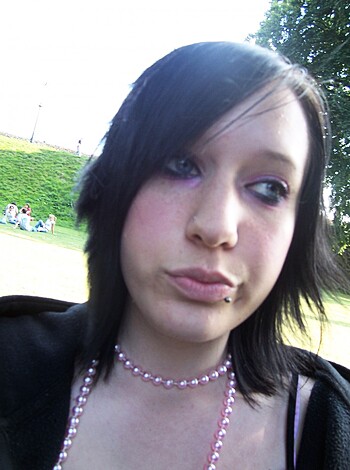 """
Hot chick with piercings in her lips and brows, wearing a skimpy tank top and bling.
"""