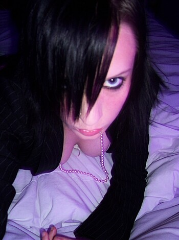 """
This image is a fucking close-up of some slutty whore's tits and face all made up while she lies on some goddamn bed. 
"""
