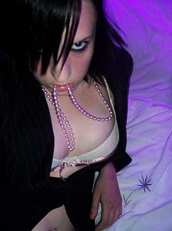 This image shows a bitch in her panties, sittin' on a fuckin' bed, lookin' right at ya.