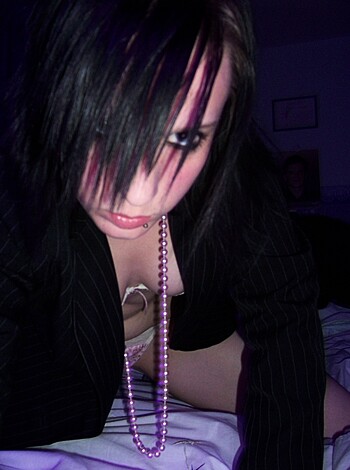 This picture depicts a slutty bitch with her bra and panties on lying around in bed while she flaunts some cheap-ass jewelry.