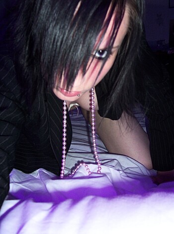 "F*ckin' hot babe with titties hangin' out on a purple and black sheets, lookin' sexy as f*ck."