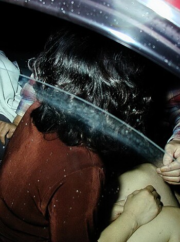 The dude's helping some chick bang in the back of a ride, like, in the dark or whatever.
