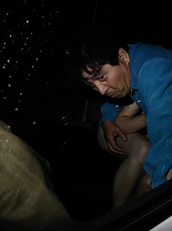 A dude is gettin' his dick out while drivin' in the dark.