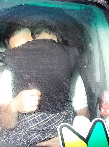 This fuckin' picture shows some hot chick cozyin' up to her lil' bitch, sittin' in a shitbox automobile while they gettin' all lovey-dovey with each other.