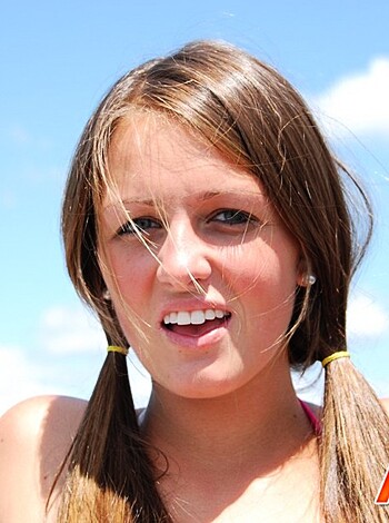 A chick with metal on her teeth, grinning like she just got a fat one.