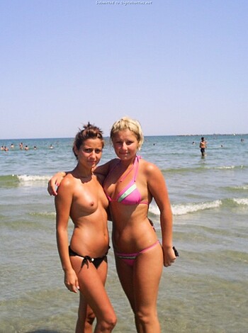 A couple of broads in bikinis at the shore, gettin’ their tan on and flauntin’ their jugs like goddamn trophies for all these horny dudes to gawk at.