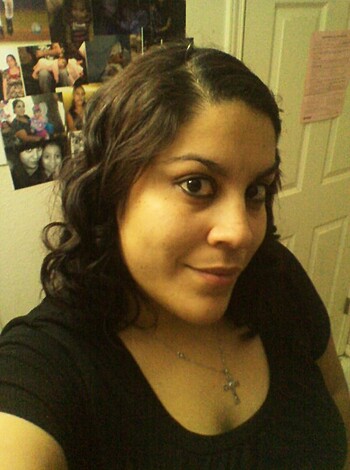 A busty chick sporting a black tee, with a smug grin on her face, poses for the lens.