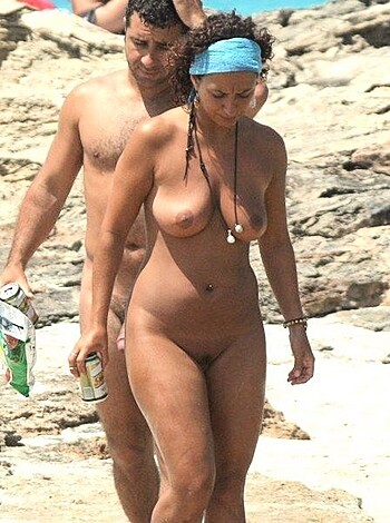 Two naked fuckers strollin' along a rocky shore, dude carryin' drinks.