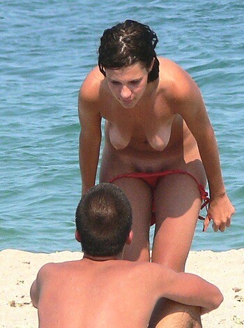 "This image is of a busty chick with her tits hanging out, gettin' gangbanged by some dudes ass while they're all fuckin' on the beach, balls deep in that pussy."