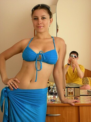 This image depicts a woman posing in a skimpy bikini, while a dude takes some sick snapshots of her ass and tits from up-close range.