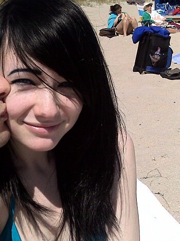 A naked babe, sunbathing on the beach, with a fucking smile on her face.