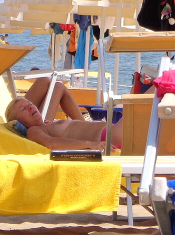 A nude bitch chillin' on a beach chaise lounge.