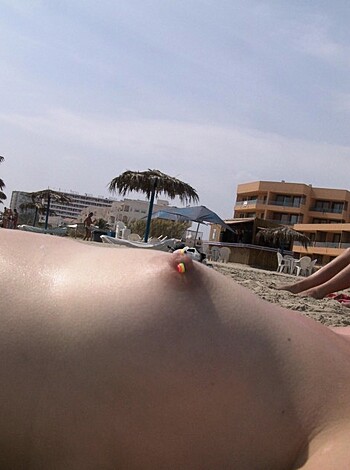 A nude bitch with tits and nipples sunbathing on the shore.