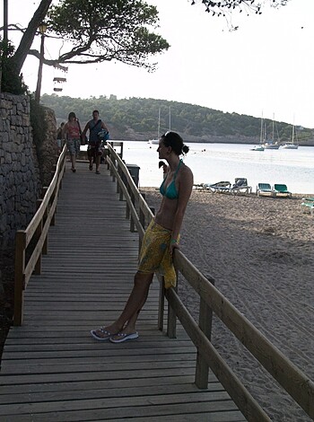 """
Check out this hot babe by the sea! She’s dressed in a skimpy bikini, sunbathing her tits off while admiring the view. Get a load of that fuckin’ body!
"""