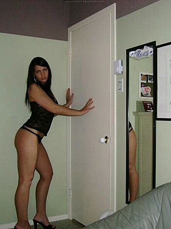 A nude chick, her left boob hanging out, is striking a pose with one hand on her slim waist while she coyly looks over her shoulder.