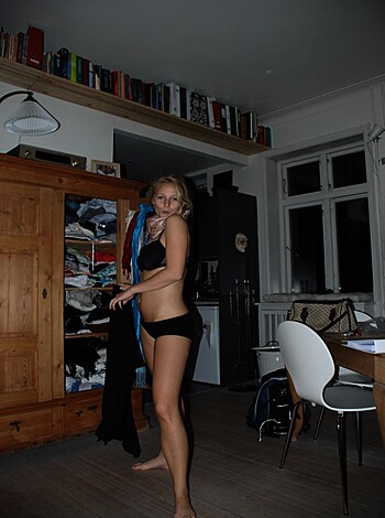 A hot blonde babe with big tits, wearing a skimpy bikini, looks directly into the camera lens and smirks as she holds a cute little kitty cat with a fucking blue ass furry tail in her hands.