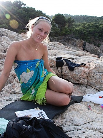 Vulgar description of Image: 
Look at this goddamn picture of some hot babe sittin' ass-naked on a fucking rock by the ocean with a green and white dress covering her tits. She's got a bottle of booze, a backpack full of shit, and a frisbee thrown nearby. Man, I'd tap that pussy if she wasn't so far away from me!