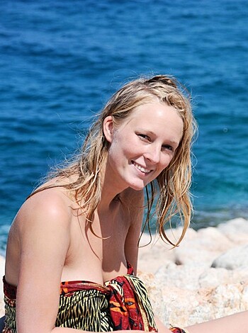 "Here's the image of some hot bitch, posing on the fucking rocks by the ocean with her tits out, showing off her tight ass body in a little bikini that barely covers her pussy lips. She's all smiley and shit, looking right at ya like she wants to fuck. Fuckin' A, that's a sexy picture."