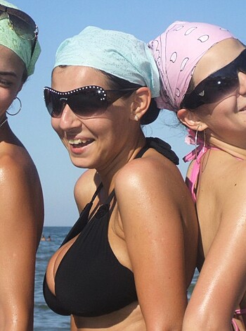 A trio of smoking hot chicks in skimpy swimwear enjoying the sun and surf on a sandy shoreline, flaunting their curvy asses and perky tits while frolicking in the waves with reckless abandon.