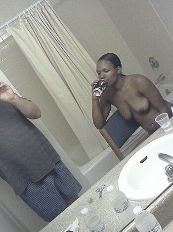 "This fuckin' photo shows a hot chick pissin' on a throne while sluggin' back brews with her tits out. Her man's snappin' shots of the scene from behind the john door, as the sink and mirror reflect all the action. Shit, this picture might even go viral."