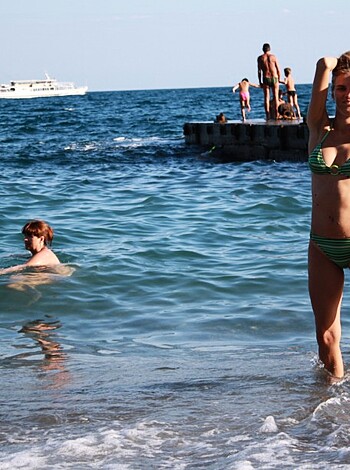 A fuckin' hot chick in a tight-ass wetsuit, bending over with her tits out and ass in the air, snapping a sexy selfie for Instagram followers to drool over.