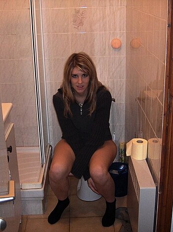 Here it is - a naked bitch sitting on the shitter, showing off her pussy and ass crack.