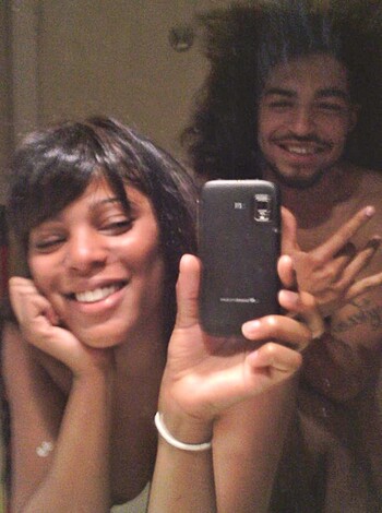Here's the fuckin' caption:
 A topless bitch and her cocksucker boyfriend standin' in front of a goddamn mirror, snappin' a selfie. The dude's givin' the finger.