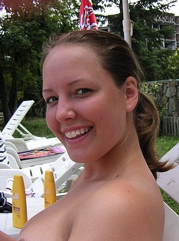 A shameless hussy sits poolside with her knockers out, reading a book and grinning like the slut she is.
