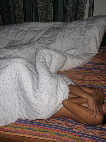 A nude chick lying on her back with a shit-eating grin on her face.