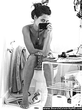A naked bitch squatting on a shitter.
