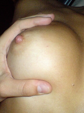 A dick-sucking handjob is being performed on two big tits.