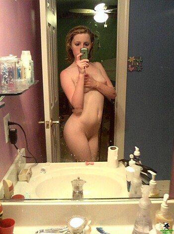 A naked chick checkin' her self out in a mirror.
