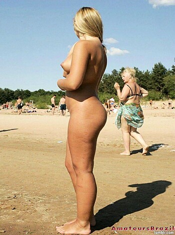 A hot chick's ass and legs on the sandy shore.