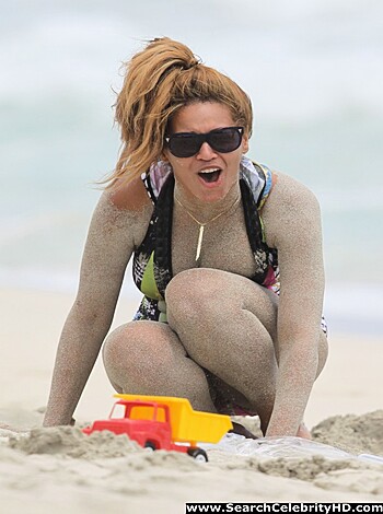 Vulgar, factual description:

"This fucking hot chick is loungin' on the sandy shore in a teeny-weeny two-piece that barely covers her tits and ass. Her skin glows in the sun as she soaks up some rays while enjoying the warm ocean breeze."