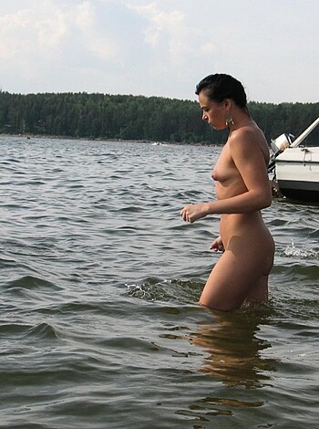 A fucking hot nude babe posing in the goddamn ocean like a god damned siren, dripping with seawater as it cascades down her milky skin, her tits perky and round, her pussy barely concealed by her spread legs, water splashing up around her feet as she stands there looking fucking stunning.