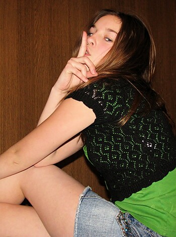 Vulgar description: Check out this hot chick making the peace sign while wearing a pair of tight-ass denim shorts and a fucking sweet emerald-colored tee. Her long hair is flowing in the breeze, and she's got a shit-ton of attitude to boot.