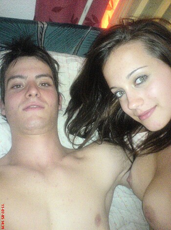 A dude and some ho, laying in bed, giving the camera a look.