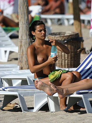 "This fucking sexy bitch is chugging booze on a sandy shore, showing off her tits and abs."