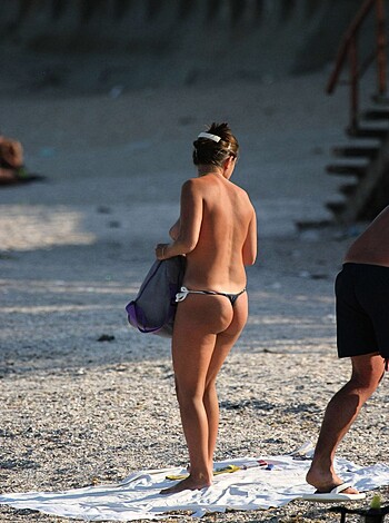 """
Hot chick with ass-revealing bikini panties strolling down sandy shore while showing off her round, perky tits and shapely legs.
"""